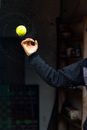 Fast spinning wet tennis ball thrown by crop man splashing water drops around