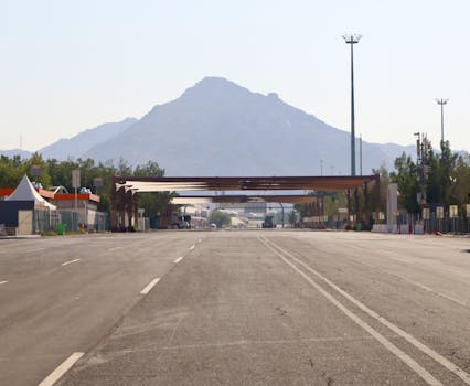 Empty highway with a scenic mountain view in the background, clear sky, daytime.