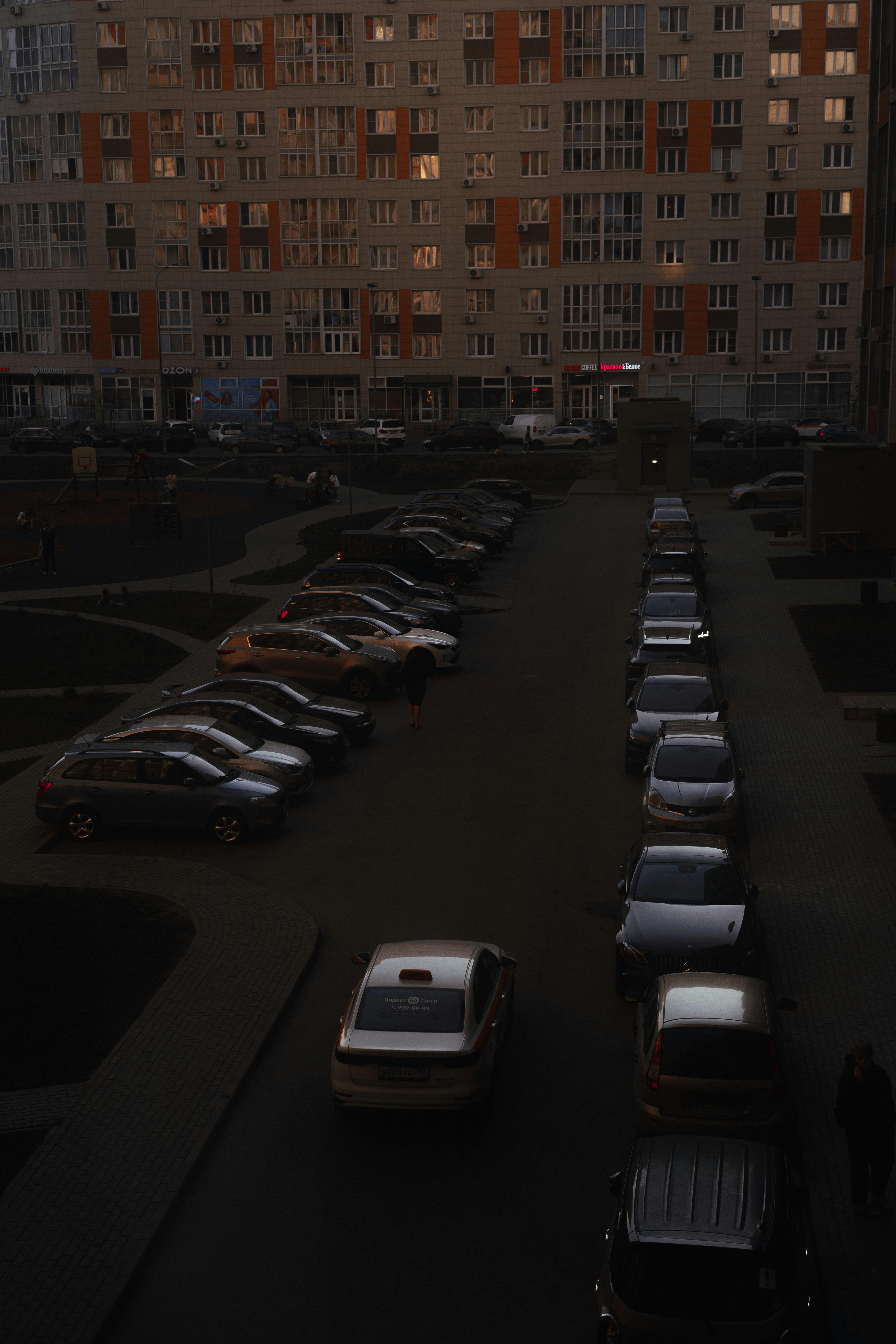 Gratis Luftfoto af et tætbefolket boligområde med parkerede biler i skumringen. Lagerfoto