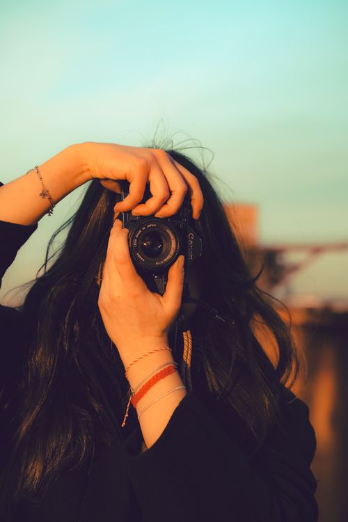 Free A person uses an analog camera to capture a sunset scene in Duisburg, Germany. Stock Photo