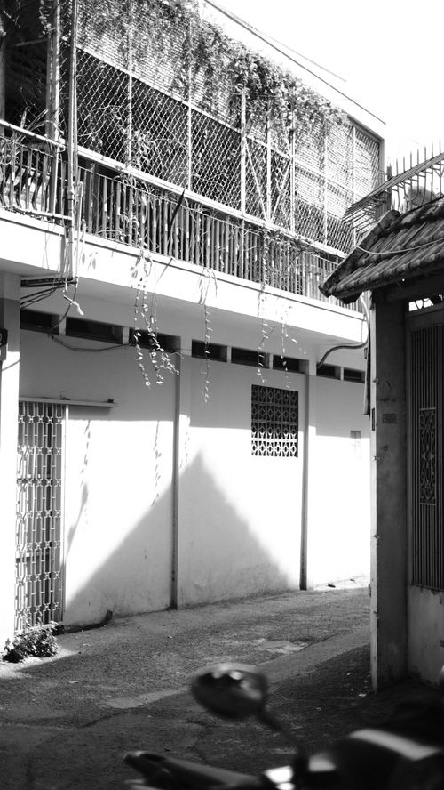 Free Monochrome photo of a quiet urban alleyway with architectural details. Stock Photo