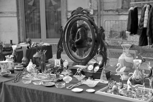 Free A black and white view of an outdoor antiques market with various vintage items on display. Stock Photo