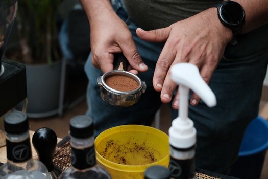 Close-up of a barista preparing an espresso shot with fresh coffee grounds in Bengaluru, India.