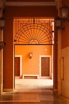 A beautifully colored corridor in Rome, featuring classic Italian architecture and ornamental ironwork.