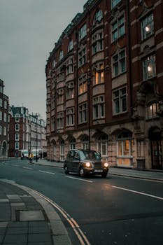 探索一条展示复古建筑的经典城市街道，一辆黑色出租车正行驶经过