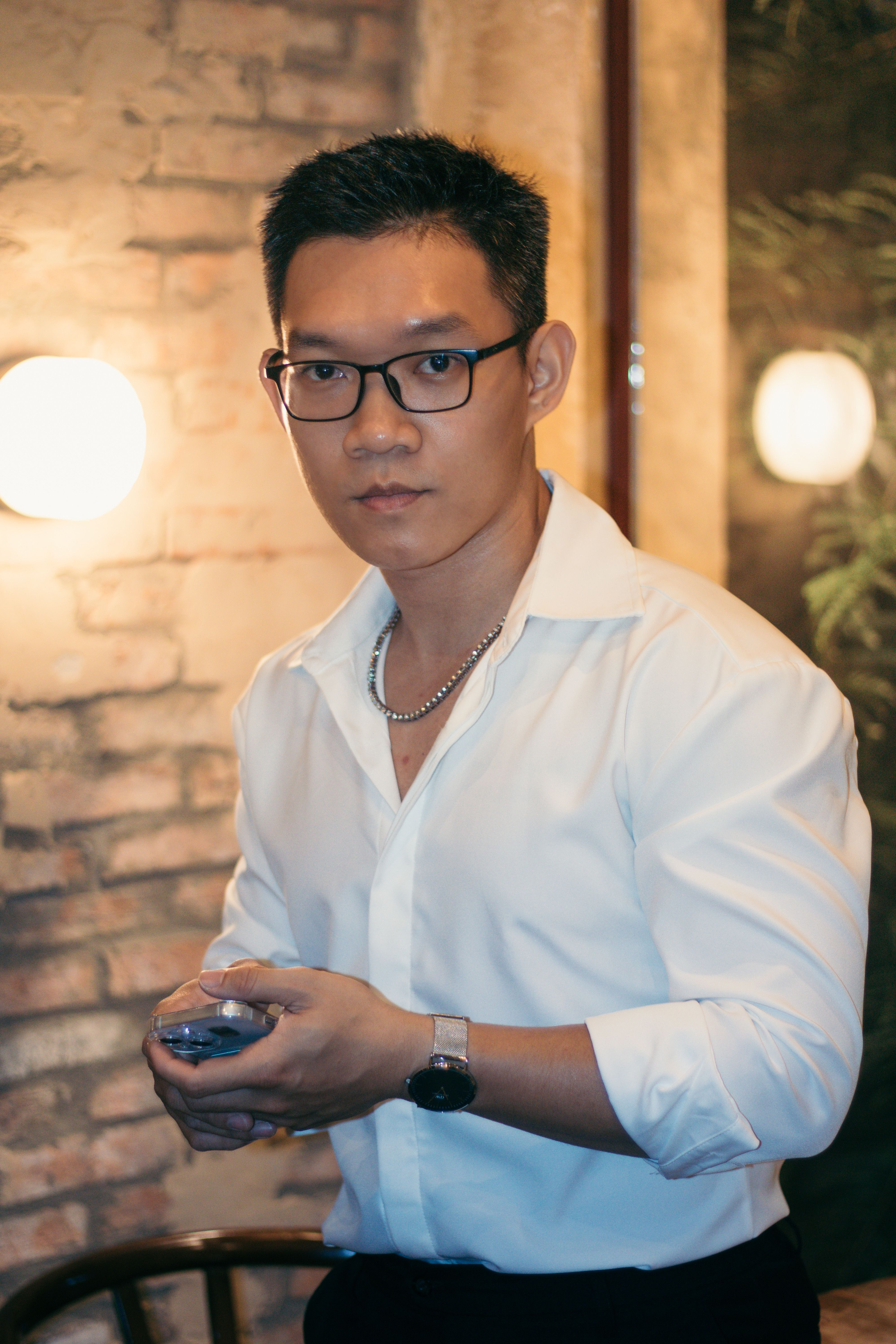 Portrait of a confident man with glasses in a stylish indoor setting.