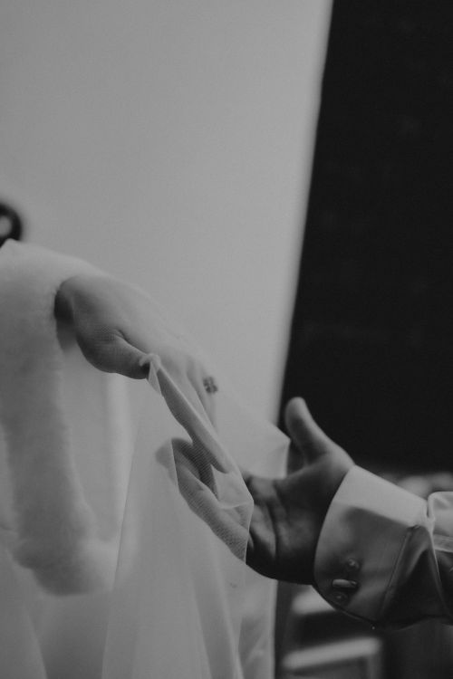 Free A black and white photo capturing a couple holding hands during a wedding ceremony. Stock Photo