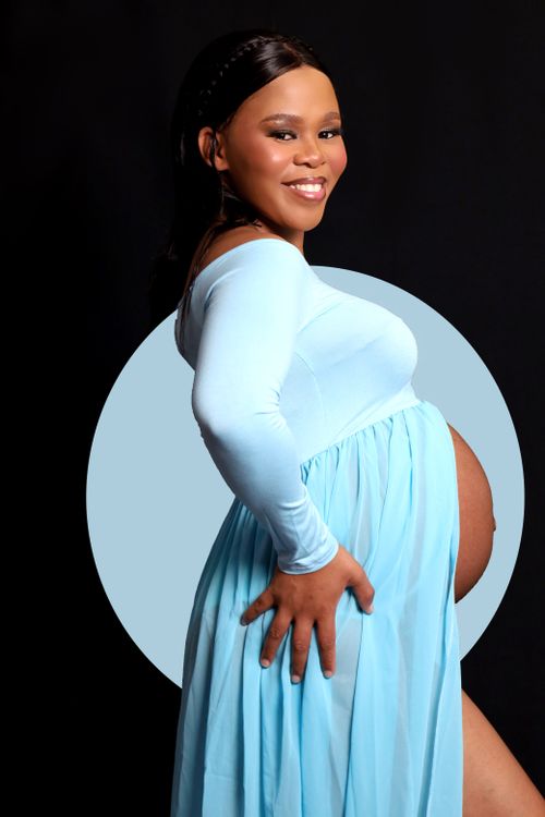 Free Portrait of a joyful pregnant woman in a blue dress, showcasing pride and happiness in maternity. Stock Photo