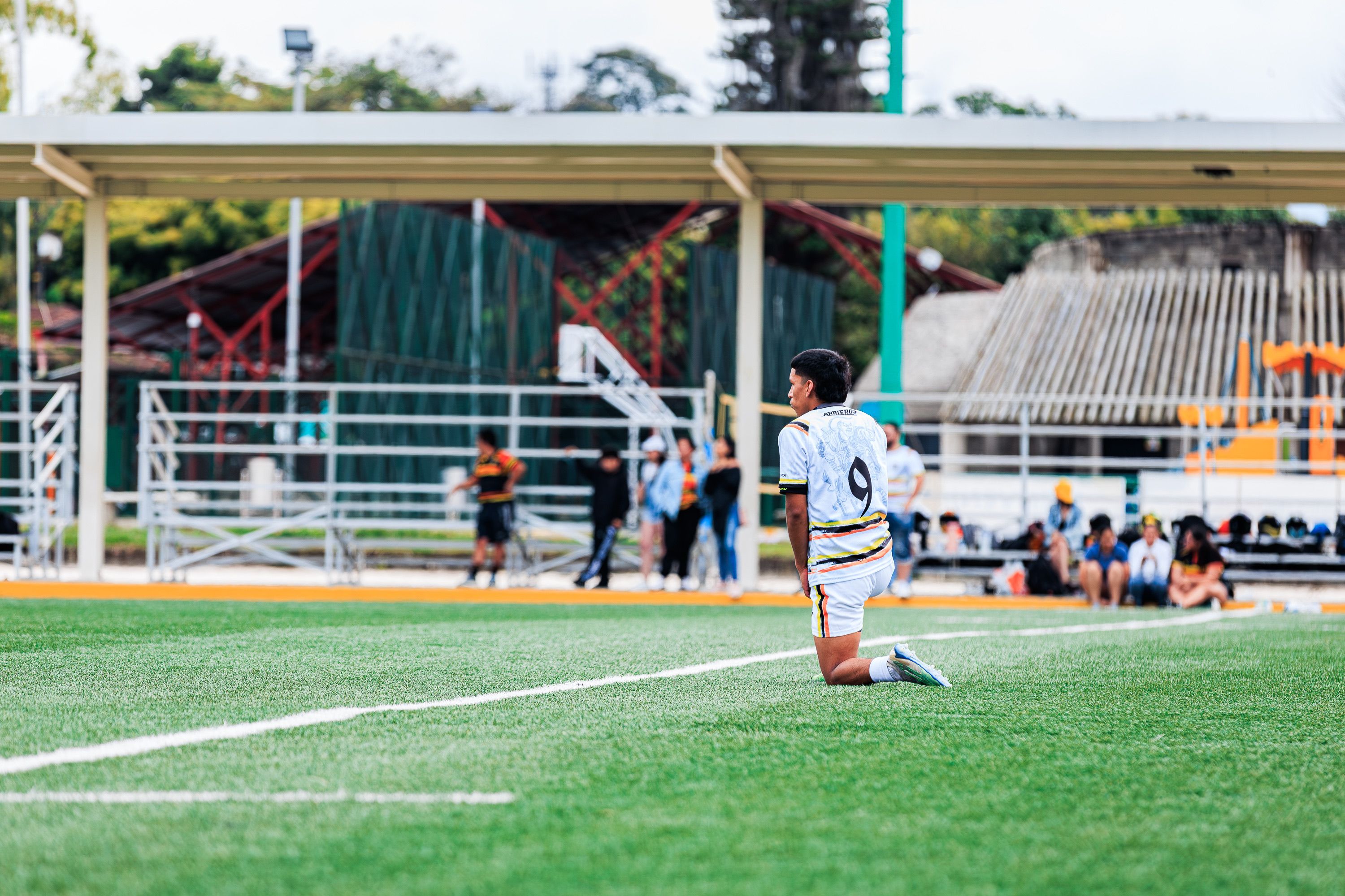 Young Soccer Player Kneeling on Field During Game