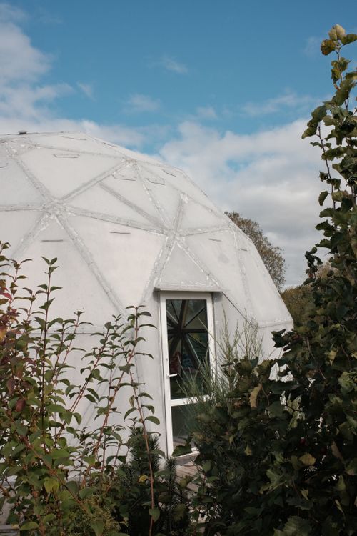 Free Geodesic dome in a serene outdoor environment with blue sky and green landscape. Stock Photo