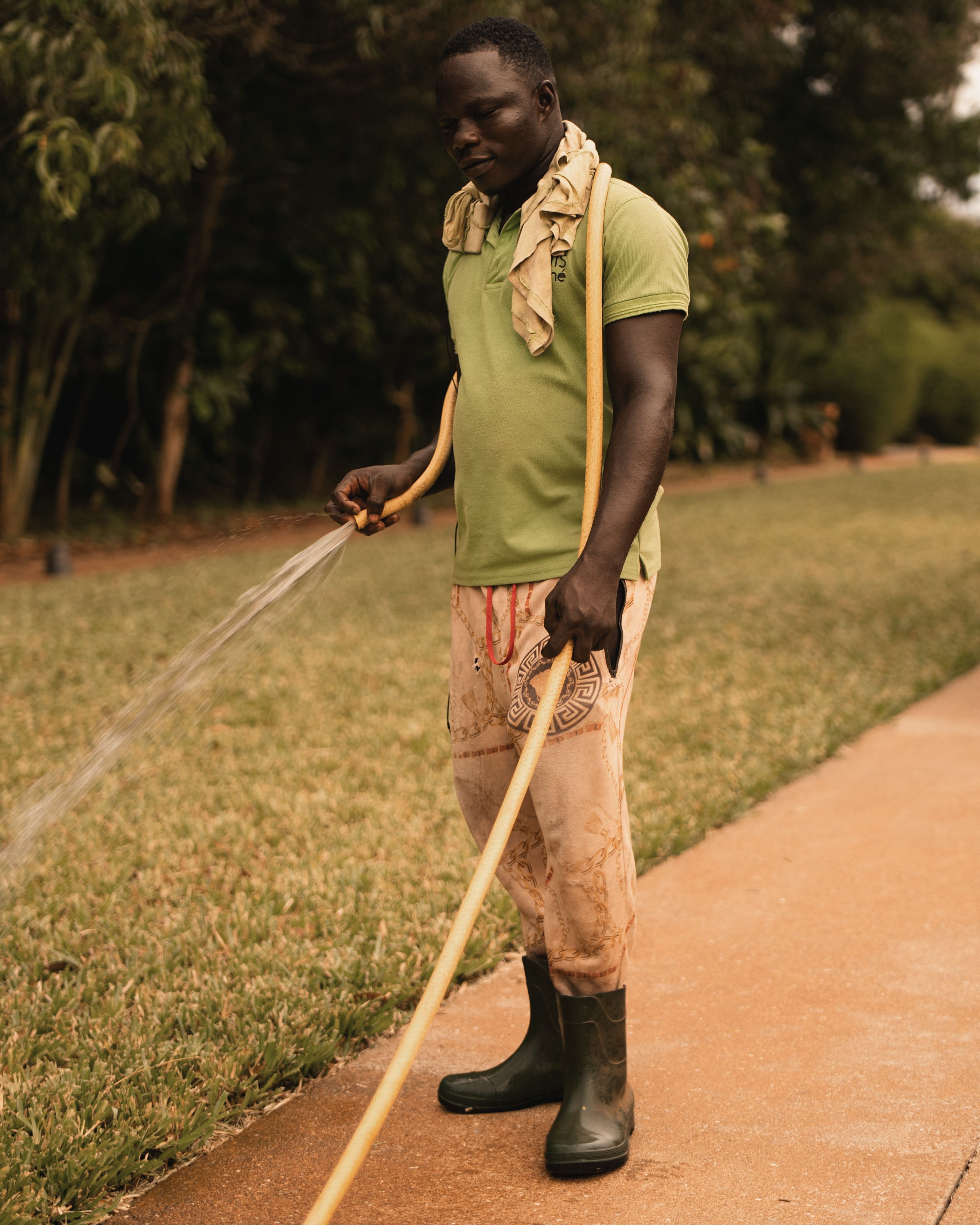 Man Watering Garden with a Hose Outdoors · Free Stock Photo