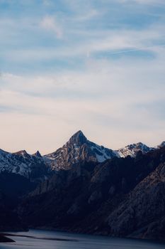Scenic view of Picos de Europa mountains in Spain with snow-capped peaks at dusk.