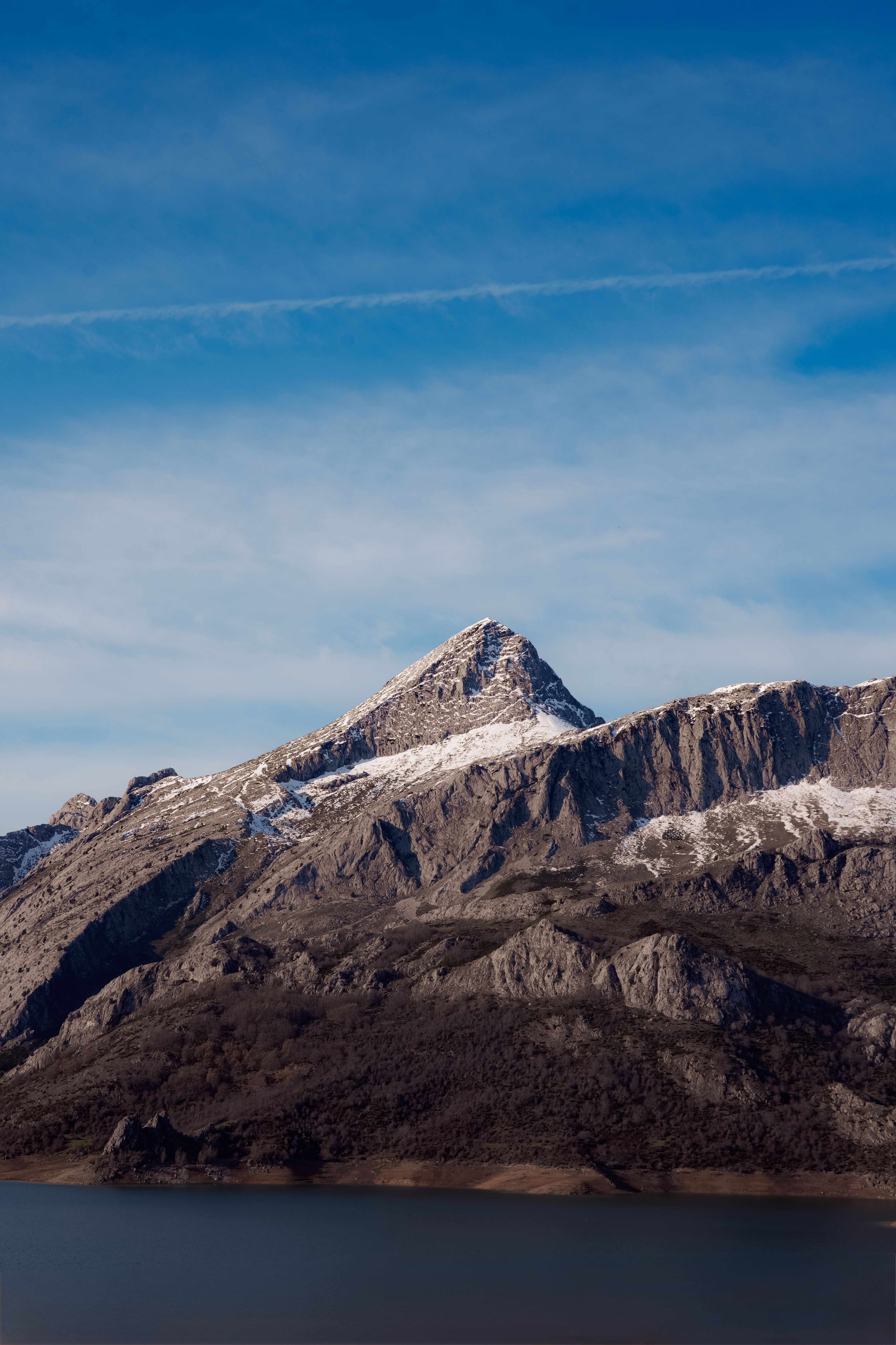 Stunning view of the snowy peaks in Picos de Europa, Spain, against a clear blue sky.