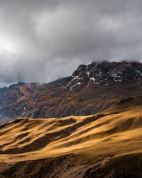 Stunning view of the Andes mountains under dramatic skies, highlighting Ausangate in Peru.