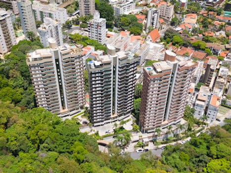 Aerial view of modern apartment buildings surrounded by lush green trees in Belo Horizonte, Brazil.