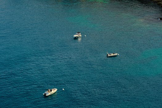 Three boats float peacefully in the clear blue waters of El Albir, offering a serene nautical view.