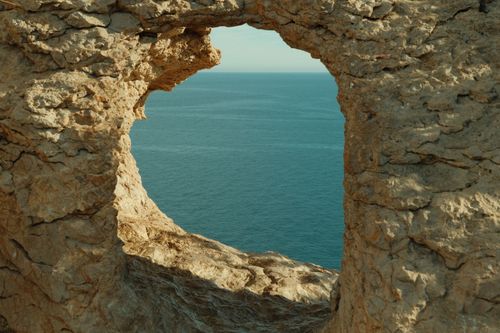 Free Beautiful Mediterranean Sea view through a natural rock window in El Albir, Spain. Stock Photo