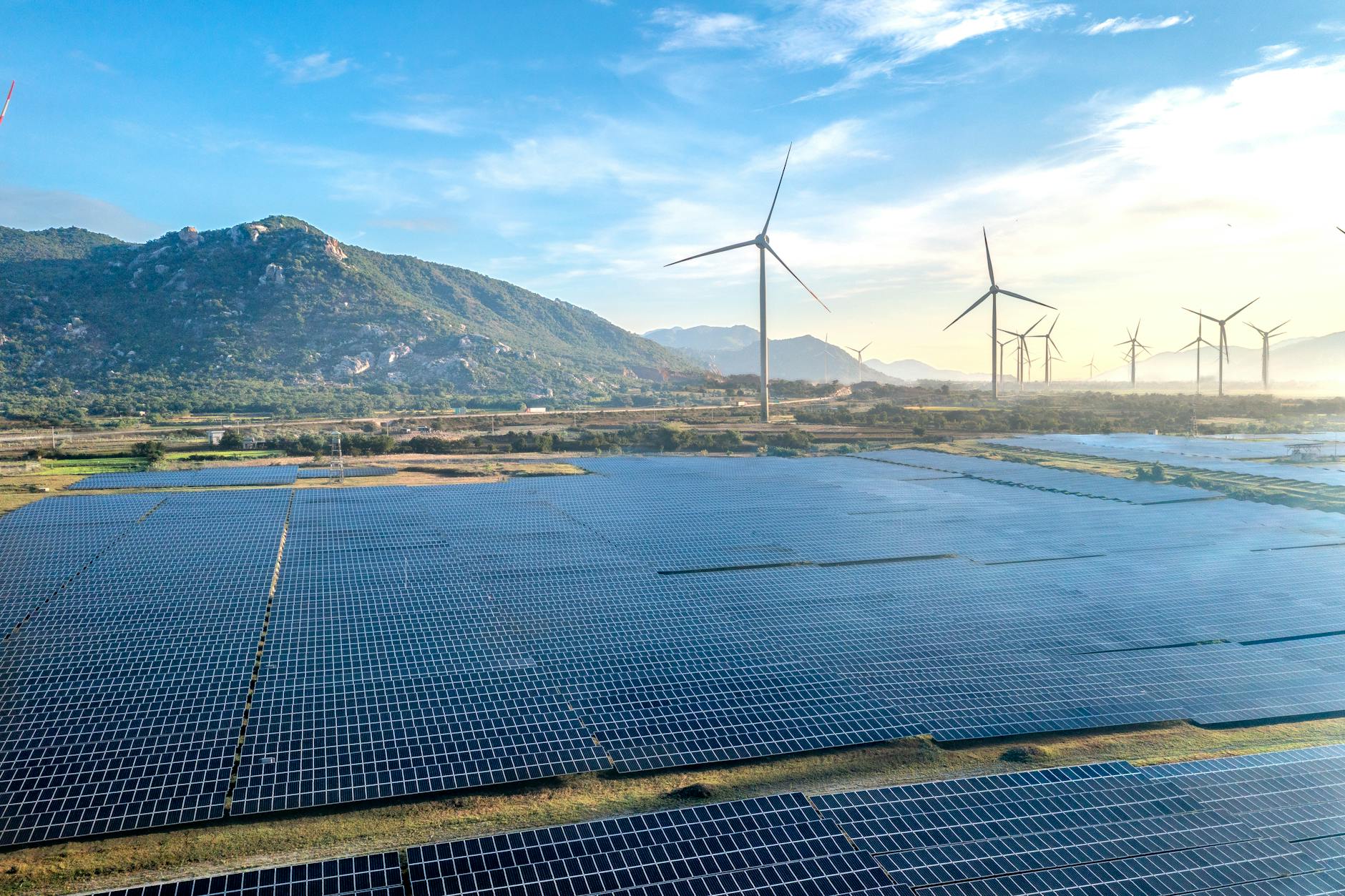 Aerial view of a solar and wind energy farm set against Vietnam's scenic landscape.