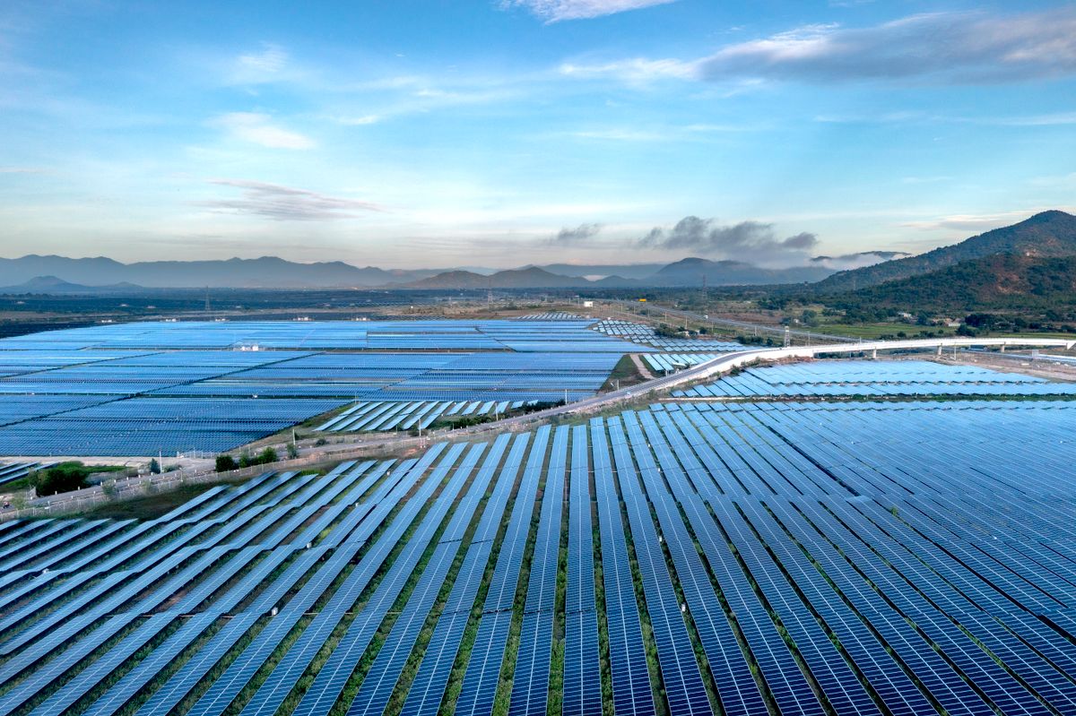 Vast aerial view of a utility-scale solar farm stretching toward the mountains