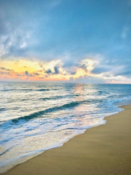 Peaceful sunrise over Kattankudy beach in Sri Lanka with gentle waves and colorful sky.