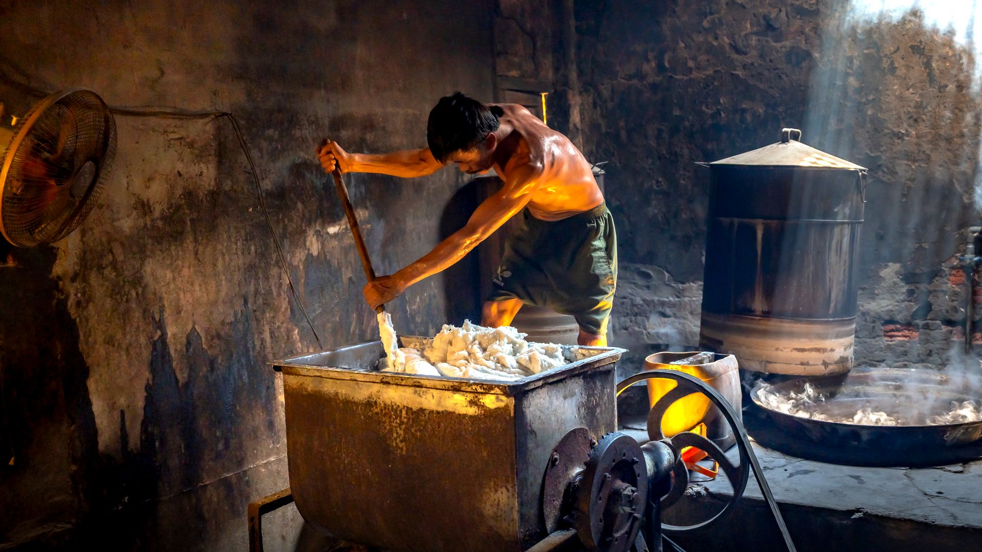 Man stirring a vat in an industrial soap factory, illuminated by natural light — what is small scale industries