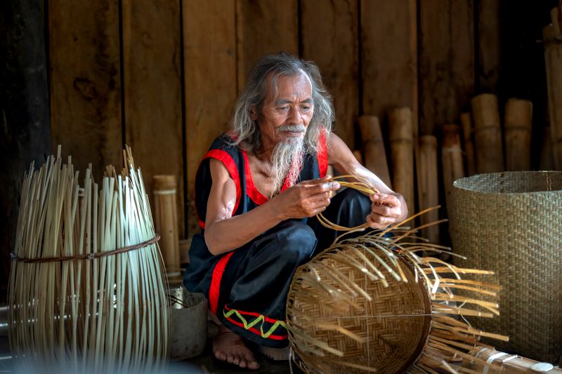 A rod-worker setting the base of a basket in the shed — photo by Quang Nguyen Vinh on Pexels