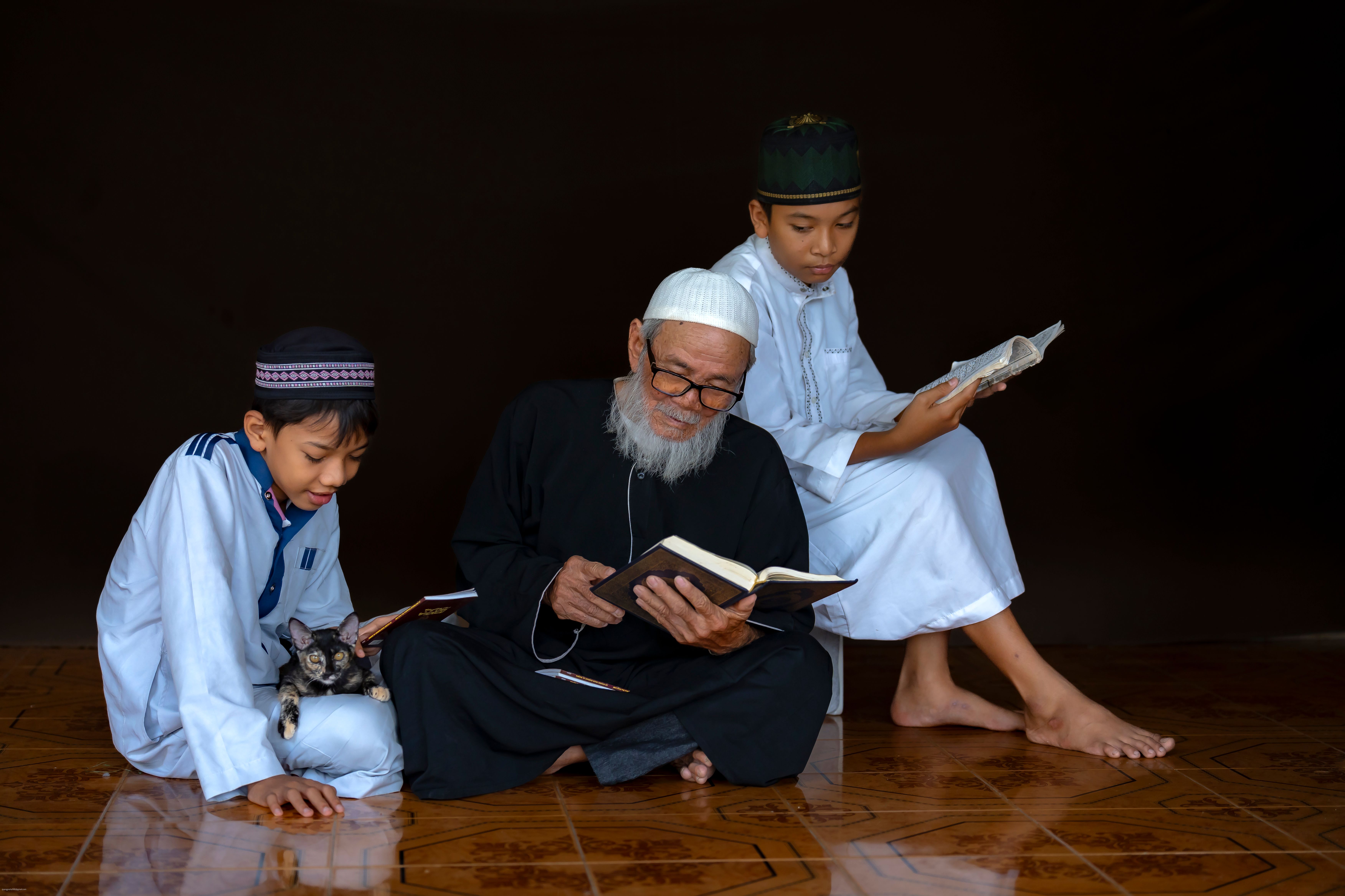 Generations Reading Together in Traditional Attire · Free Stock Photo