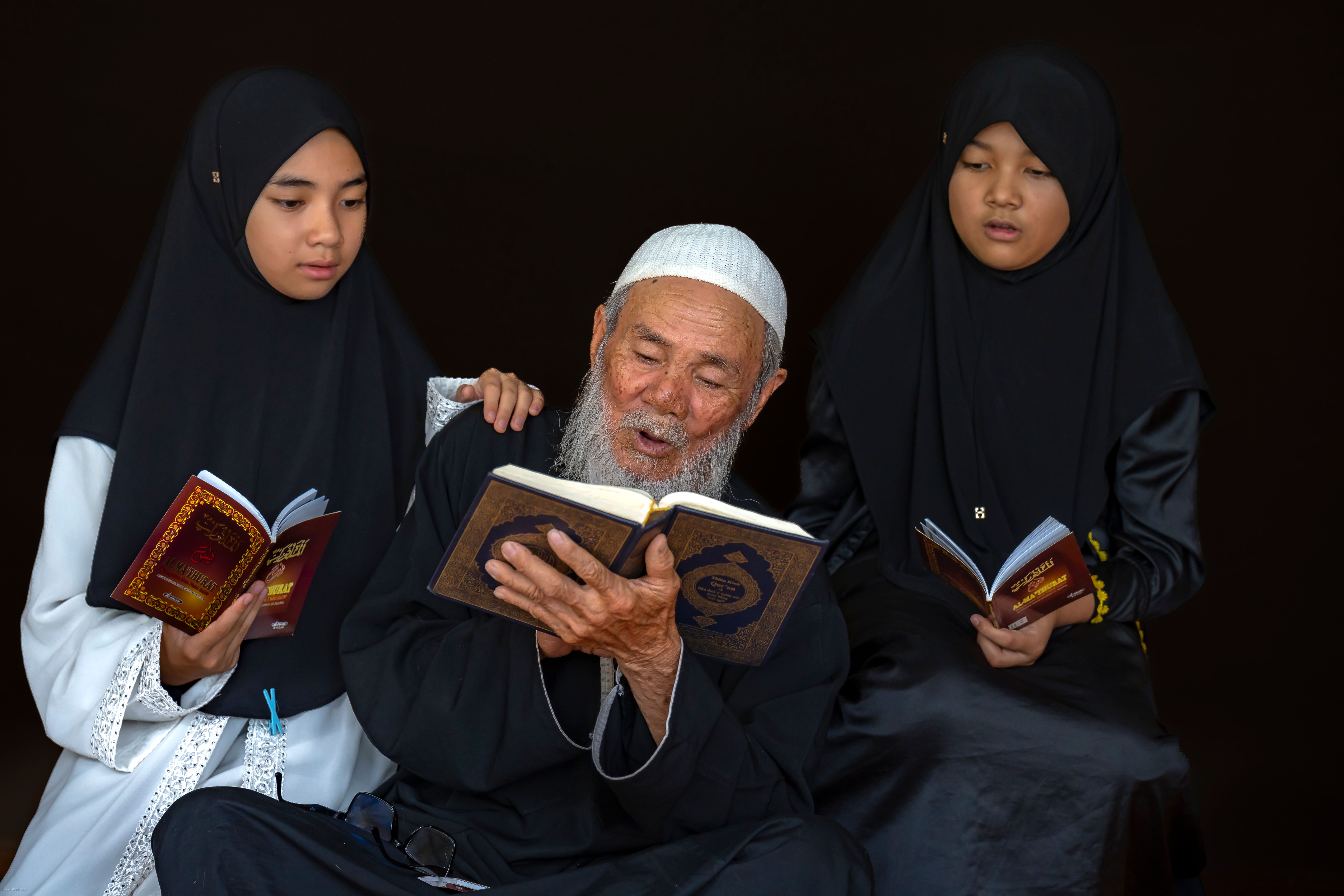 Elderly Man and Girls Reading Religious Text · Free Stock Photo
