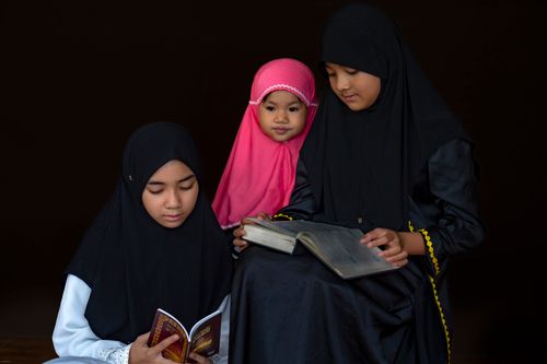 Free Three young girls reading religious texts together, exemplifying cultural and spiritual learning. Stock Photo