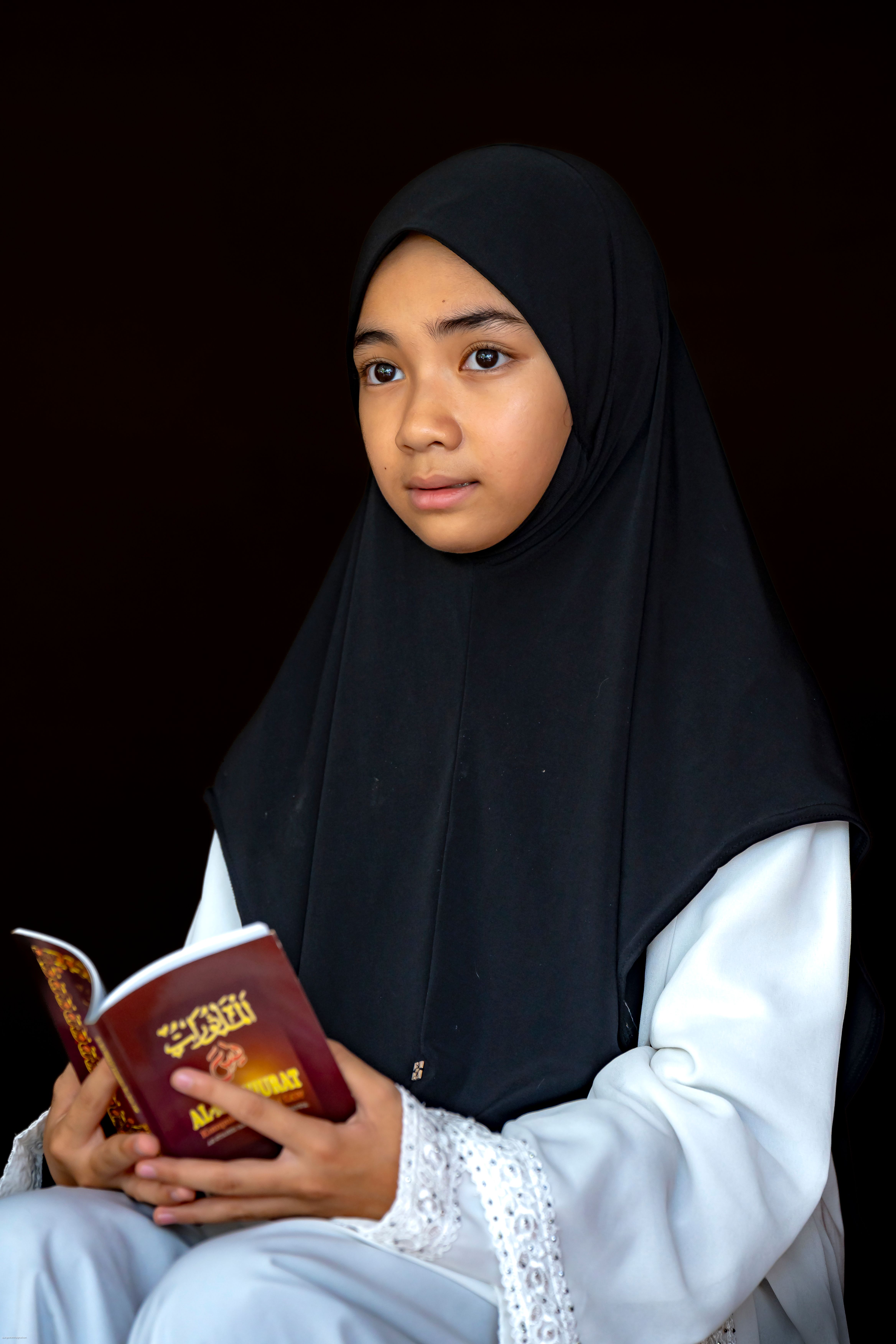 Young Girl Reading Religious Book in Black Hijab · Free Stock Photo