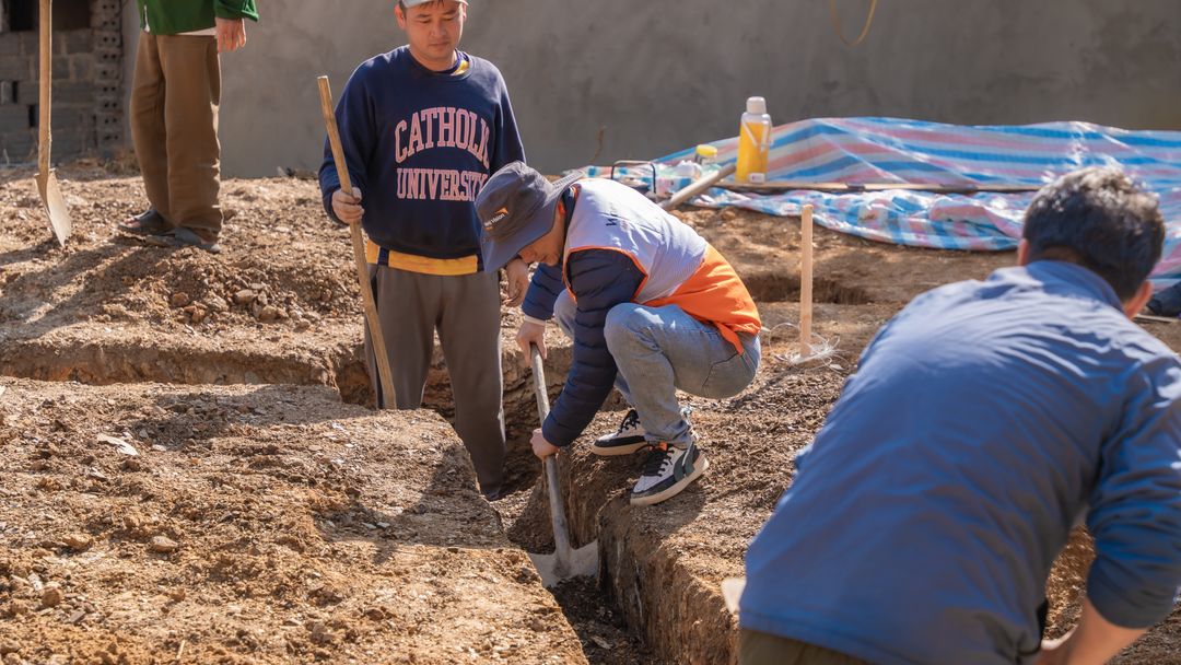 A trench being dug by hand. In loose ground the trench is the difficult half of the job, and it is what the price reflects.