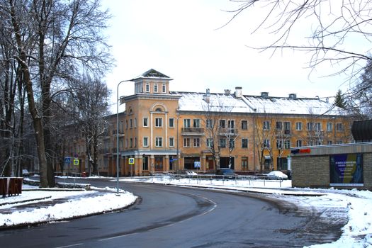 Snow-covered street in Narva, Estonia, featuring historic buildings and urban winter scenery.