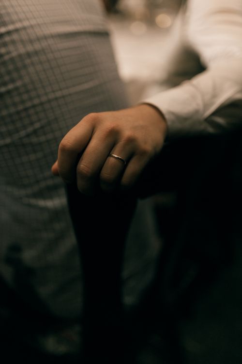 Free Close-up of a hand wearing a ring in soft focus, indoor setting, moody atmosphere. Stock Photo
