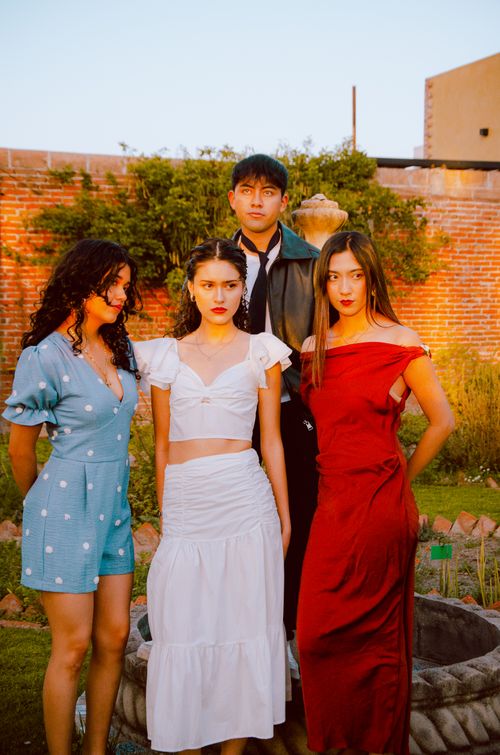 Free Group of fashionable young adults posing outdoors together in vibrant attire. Stock Photo
