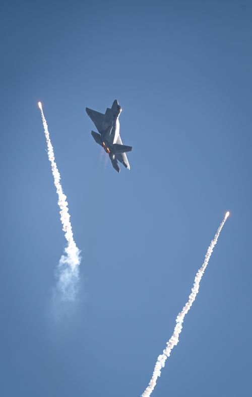 Free F-22 Raptor performs a striking maneuver with flares at Miramar Airshow, San Diego. Stock Photo