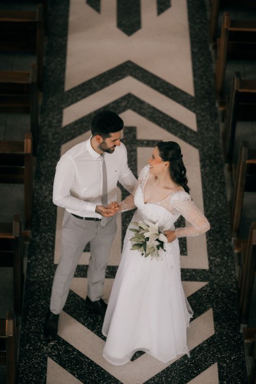 Free A bride and groom share a moment in an elegantly decorated indoor setting, showcasing timeless romance. Stock Photo