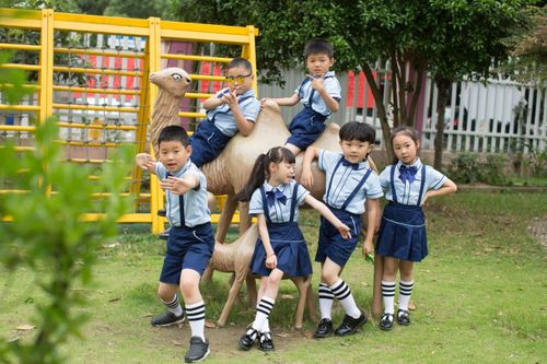 Free Group of children in school uniforms posing with a camel statue outdoors. Stock Photo