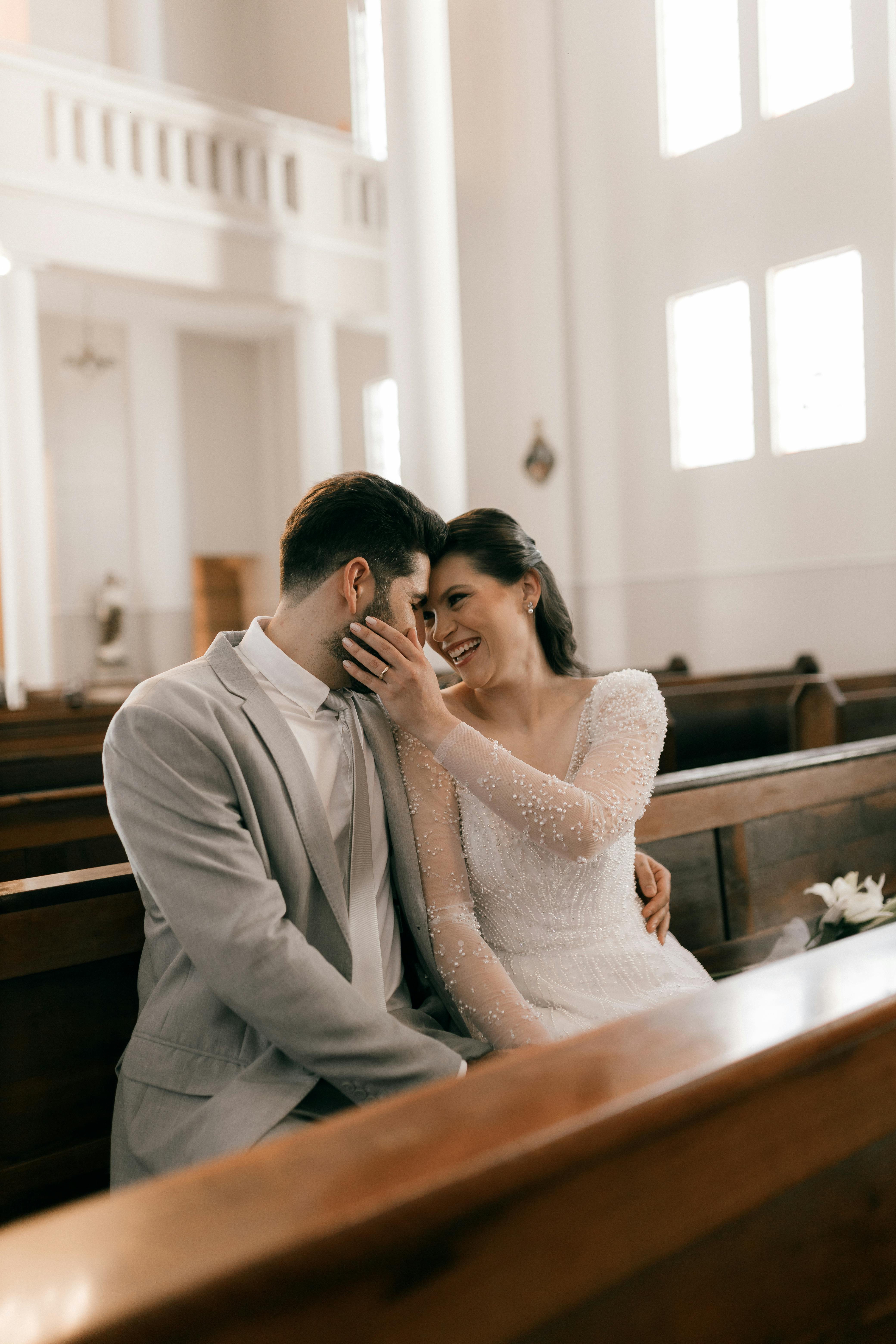 Happy bride and groom sharing a moment in a bright church interior.