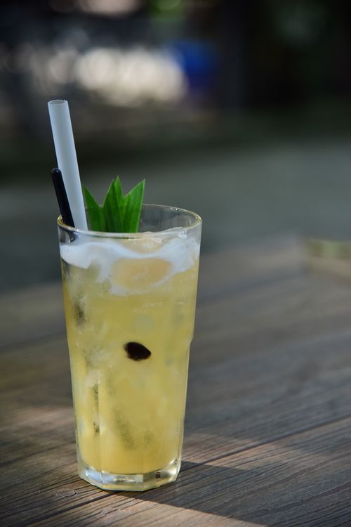 Free A refreshing pineapple cocktail garnished with leaves and served on a wooden table, perfect for summer vibes. Stock Photo