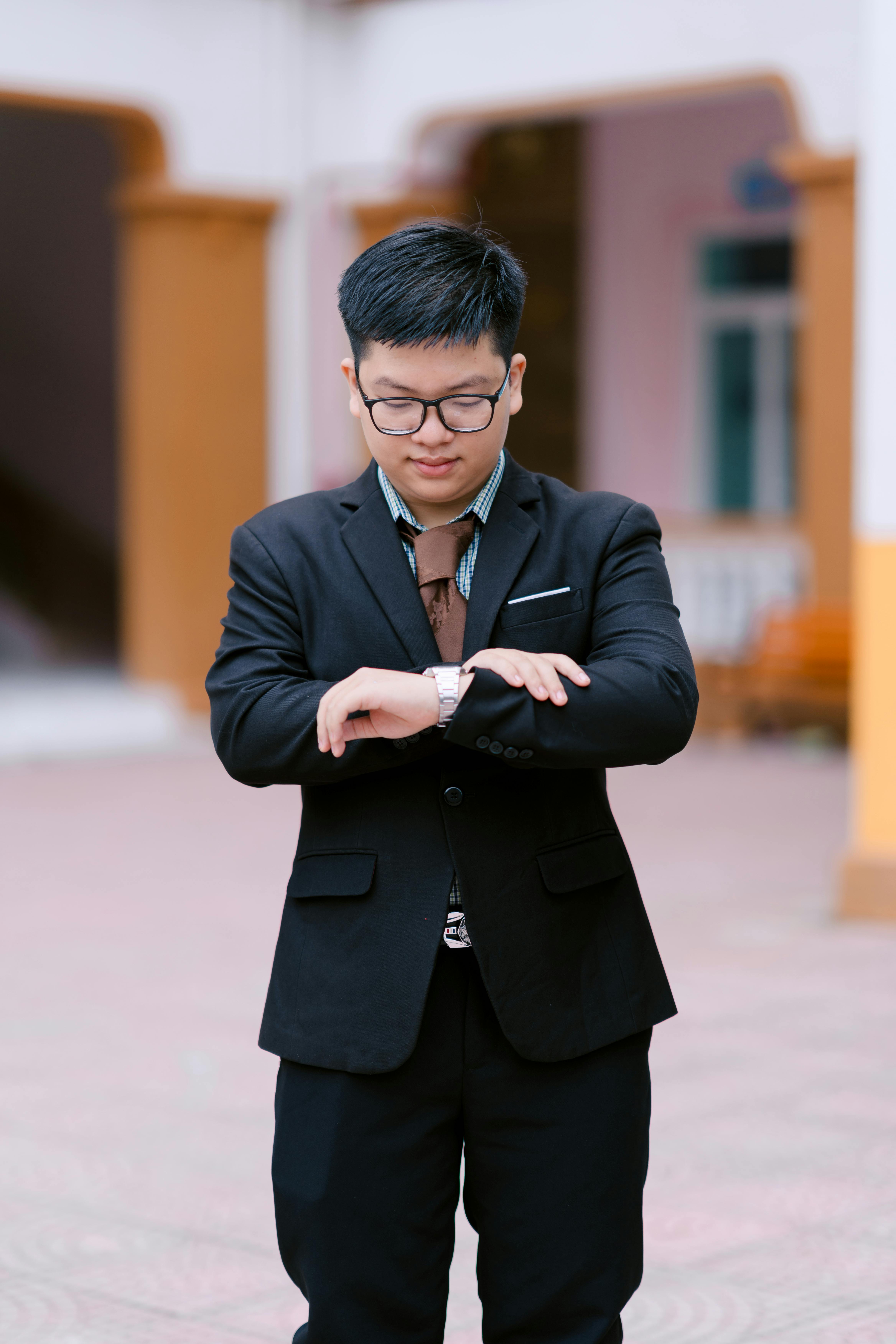 Miễn phí Doanh nhân trẻ mặc vest đang kiểm tra thời gian trực ngoài trời. Ảnh lưu trữ