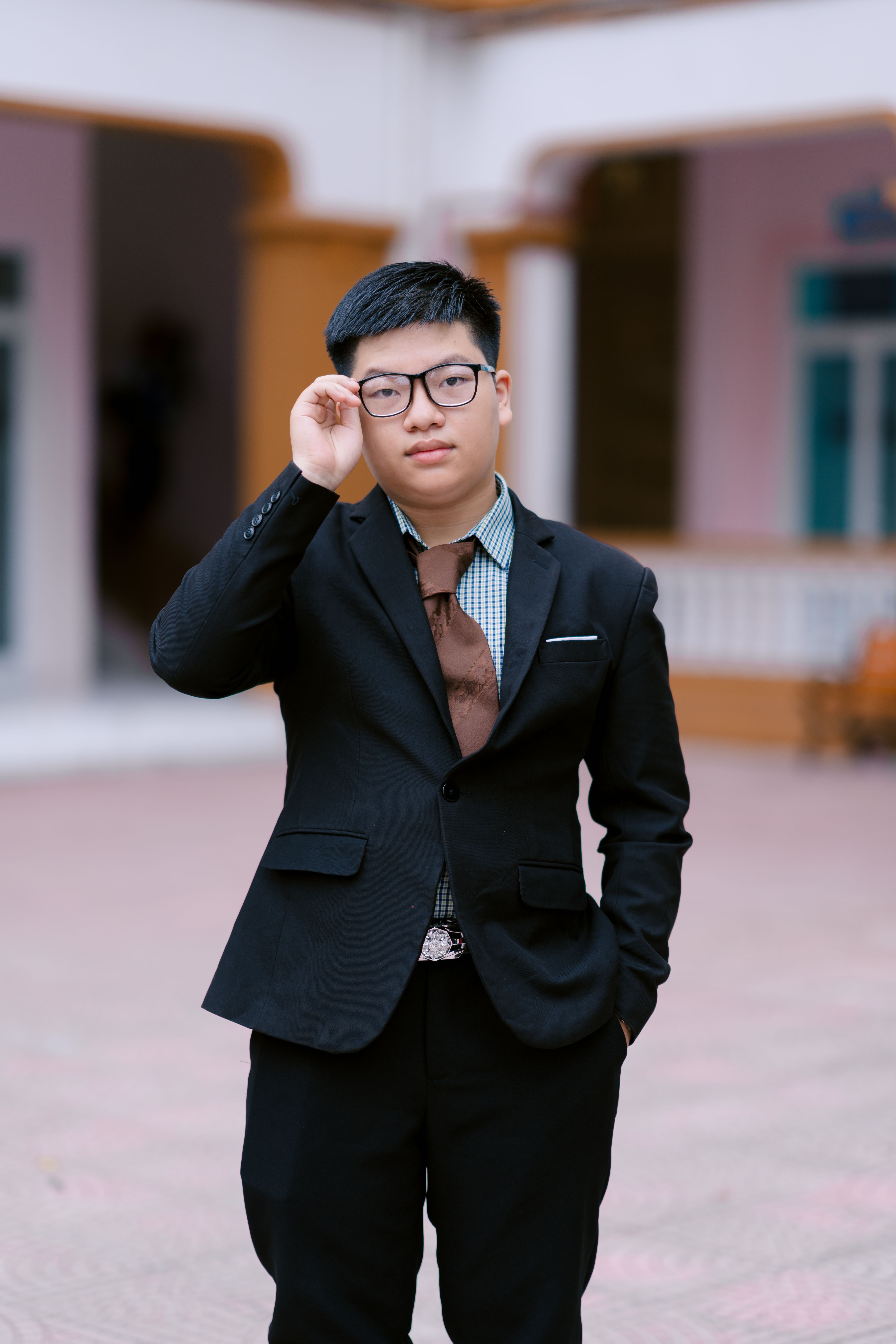 Young man in formal suit posing confidently outdoors.