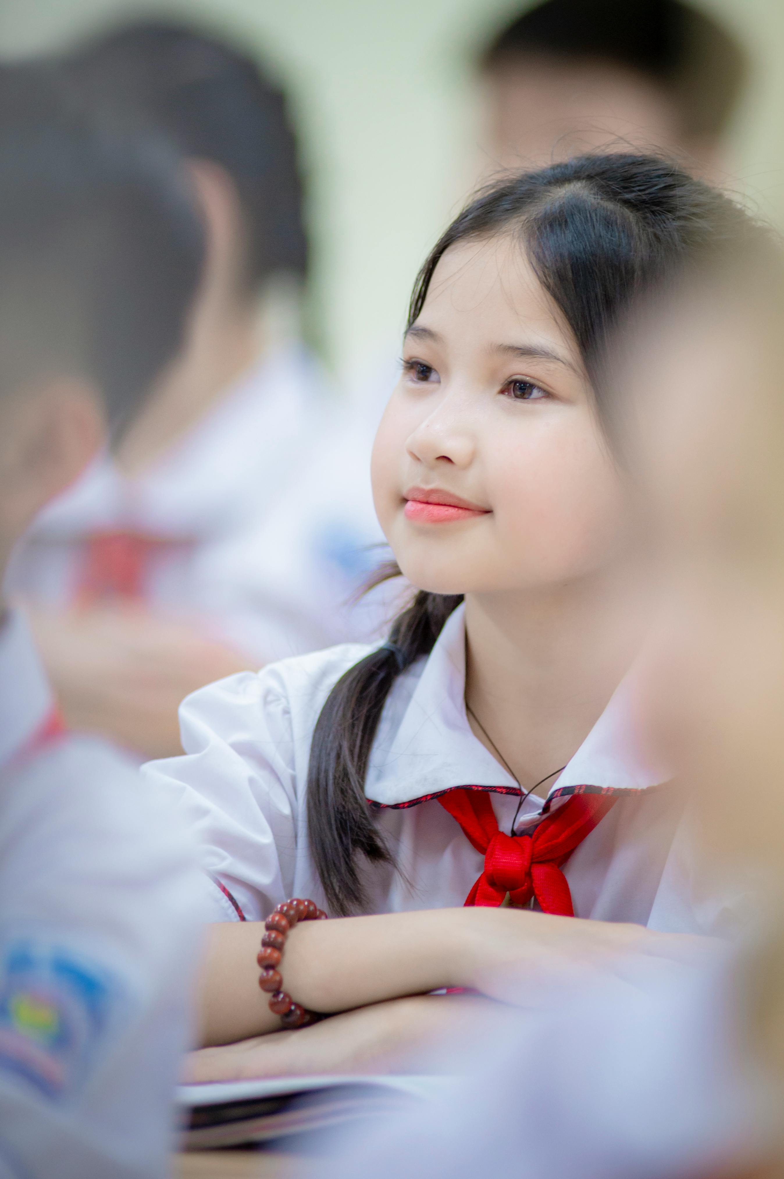 Gratis Ritratto di una giovane studentessa in un'aula ad Hanoi, in Vietnam, concentrata sui suoi studi. Foto a disposizione