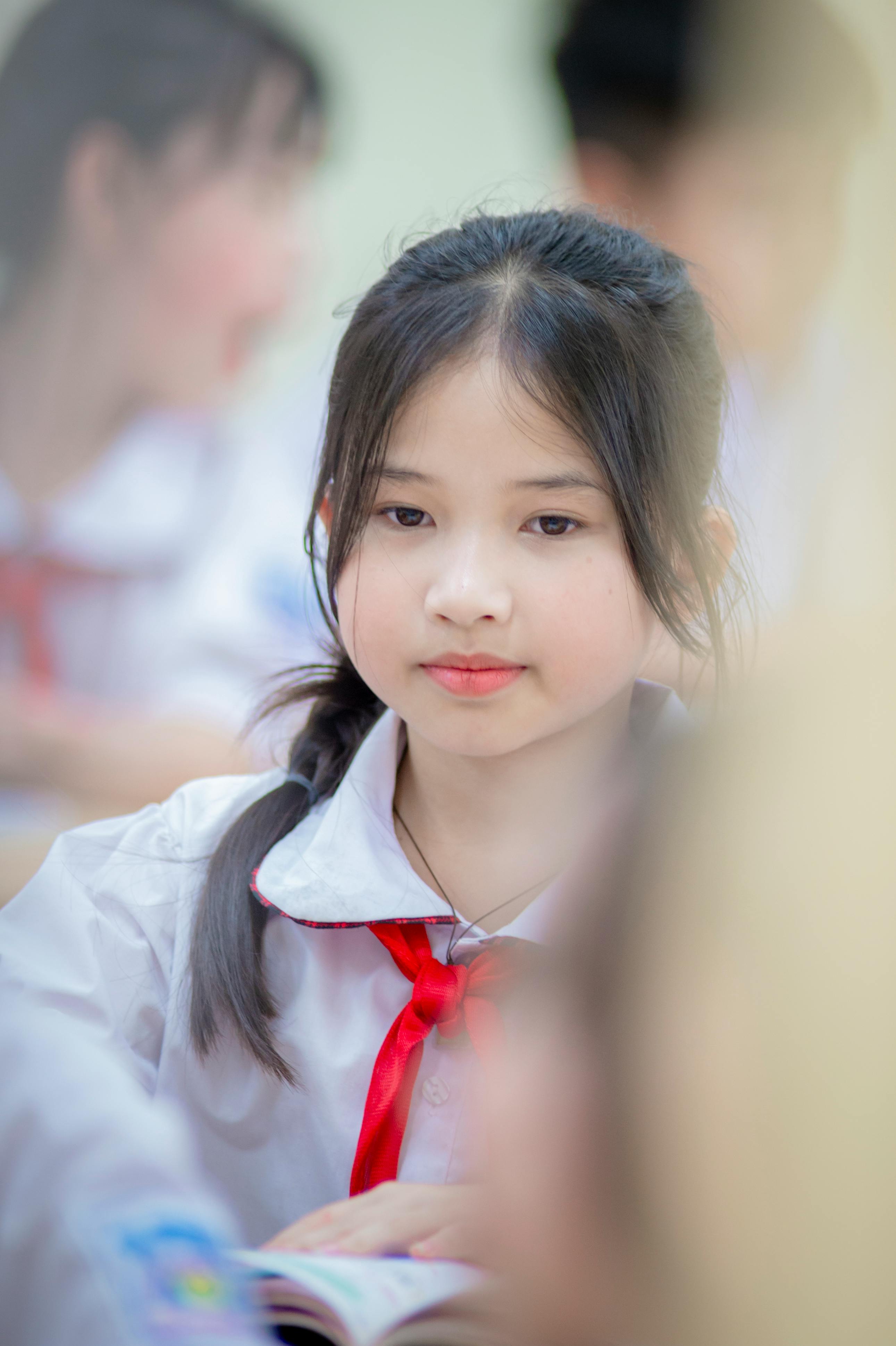 Gratis Potret seorang gadis muda Vietnam di dalam kelas, mengenakan seragam sekolah. Foto Stok