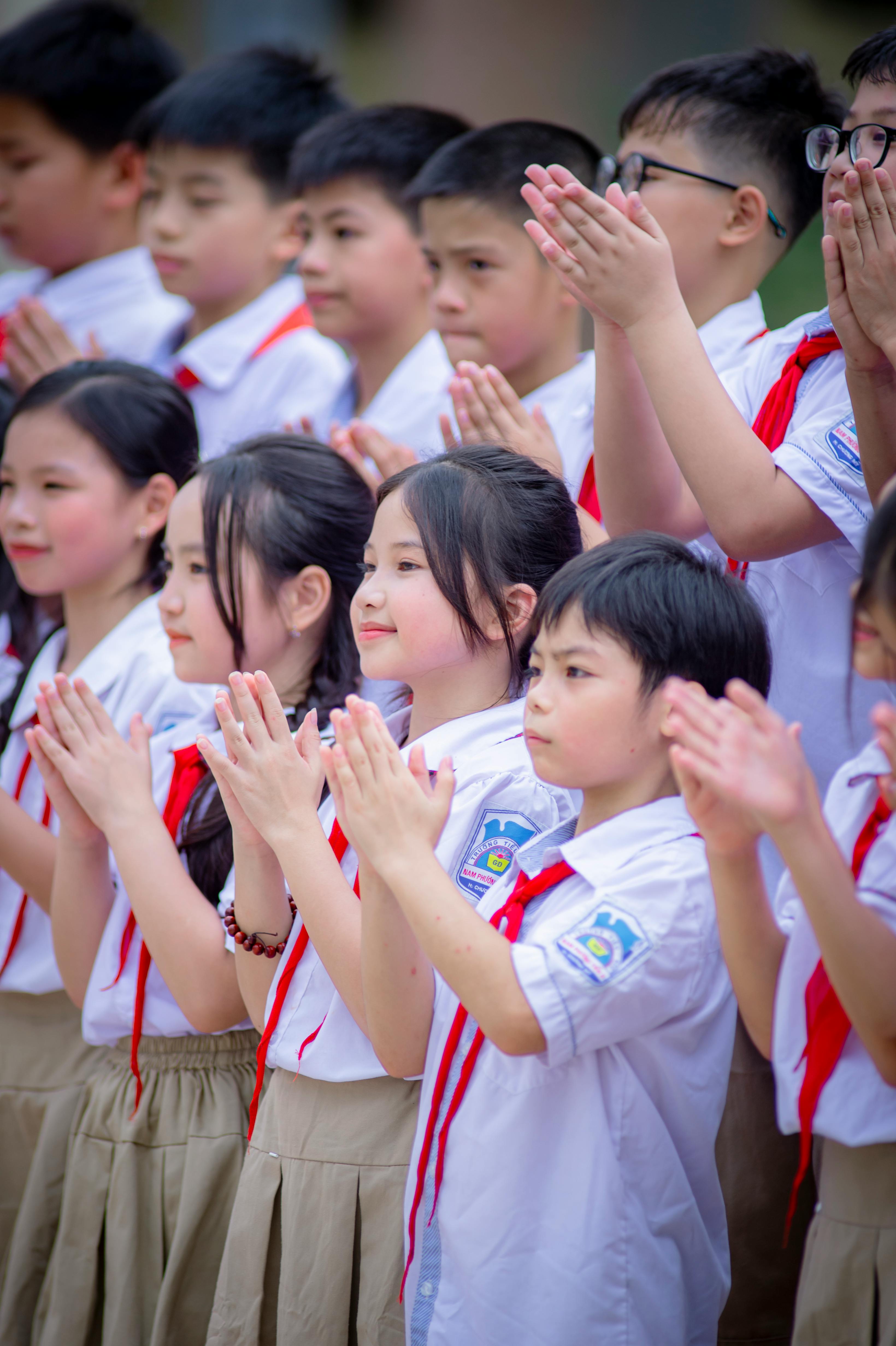Free Group of schoolchildren clapping during a ceremony in Hà Nội, Vietnam. Stock Photo