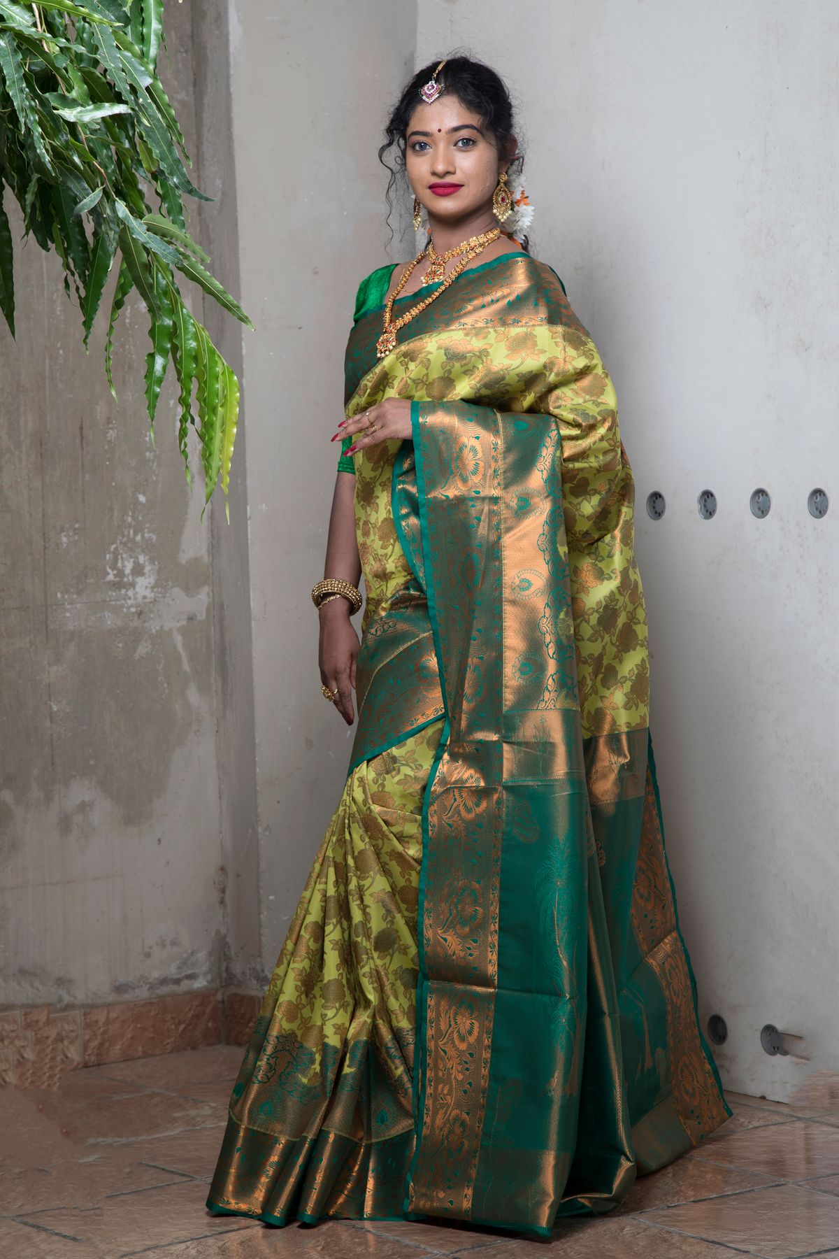 Model in an emerald-green Banarasi-style saree woven with gold zari