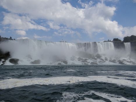 Breathtaking view of Niagara Falls with cascading waters and blue skies in summer.