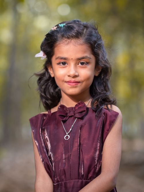 Free Portrait of a smiling South Asian girl in a stylish dress outdoors. Stock Photo