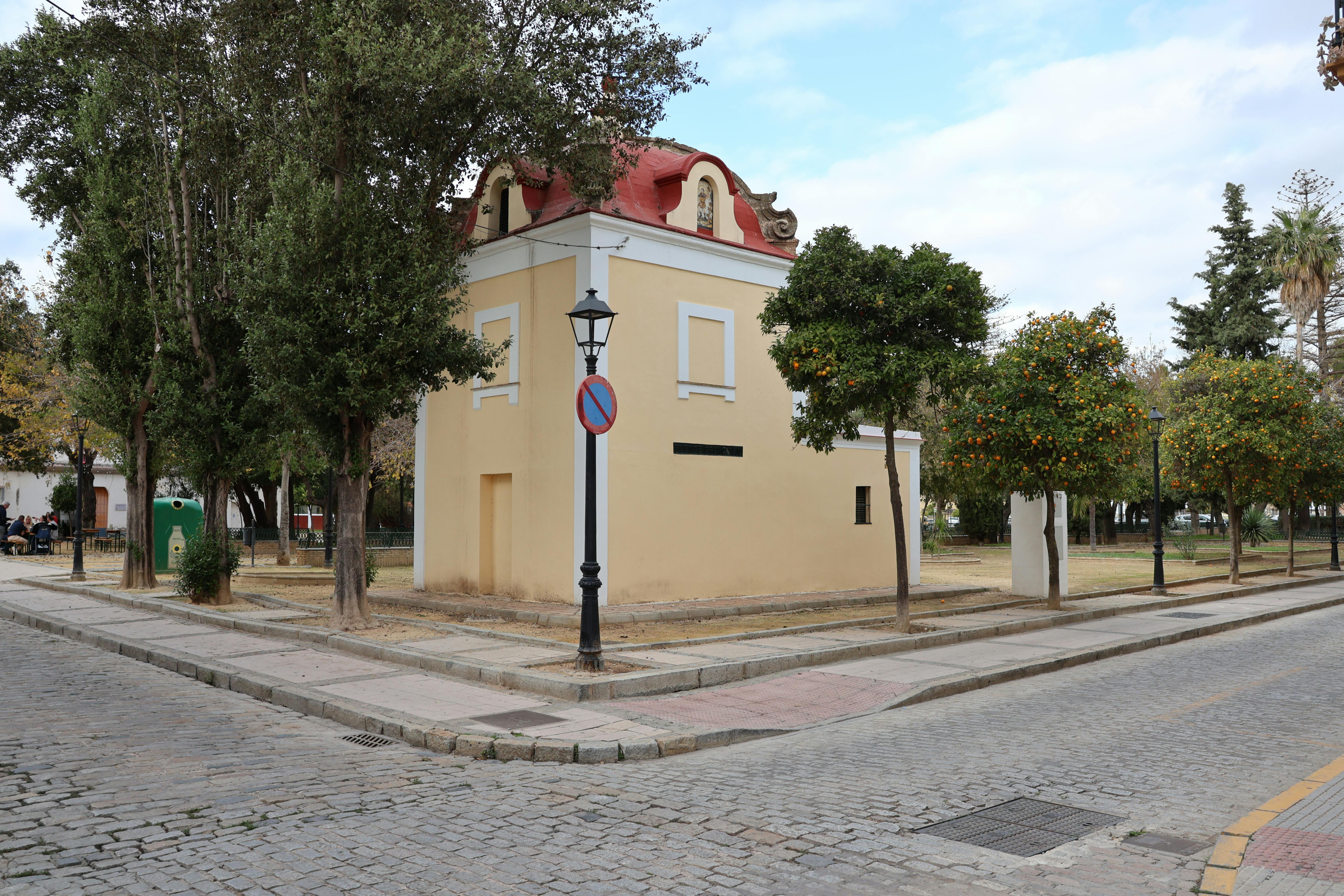 Charming historic building with trees and cobbled streets in Puerto Real, Spain.