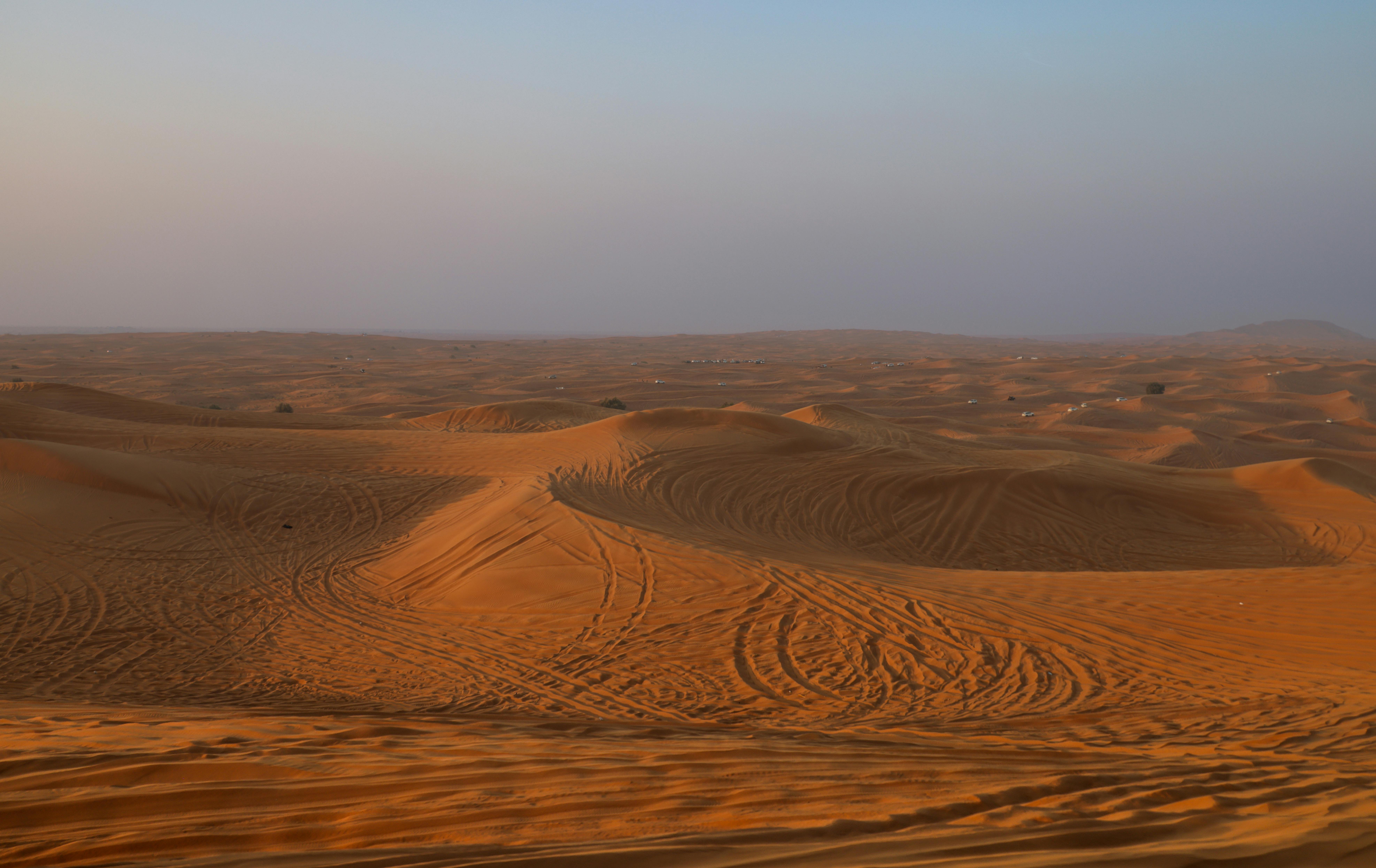 A breathtaking view of sand dunes under a sunset sky, capturing the essence of desert tranquility.