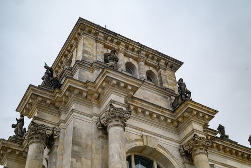 Free Low-angle view of a historical building's sculpted facade and columns. Stock Photo
